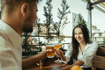 Image showing Young friends or couple drinking beer and celebrating together