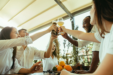 Image showing Young group of friends drinking beer and celebrating together