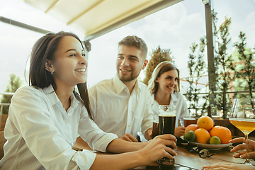 Image showing Young group of friends drinking beer and celebrating together