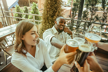 Image showing Young group of friends drinking beer and celebrating together