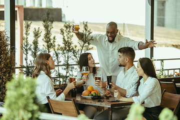 Image showing Young group of friends drinking beer and celebrating together