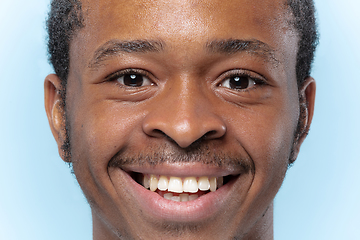 Image showing Close up portrait of young man on blue background.