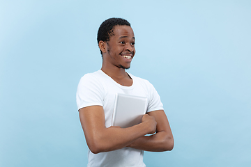 Image showing Half-length close up portrait of young man on blue background.