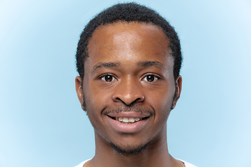 Image showing Close up portrait of young man on blue background.