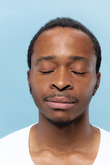 Image showing Close up portrait of young man on blue background.