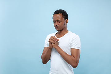 Image showing Half-length close up portrait of young man on blue background.