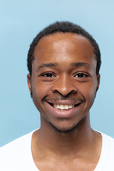 Image showing Close up portrait of young man on blue background.