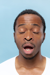 Image showing Close up portrait of young man on blue background.