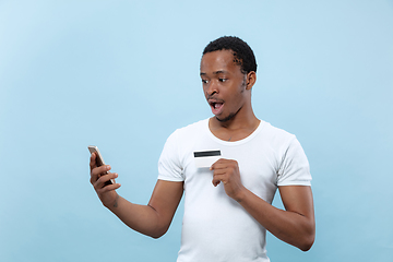 Image showing Half-length close up portrait of young man on blue background.