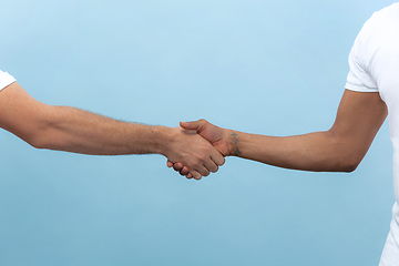 Image showing Close up shot of human holding hands isolated on blue studio background.