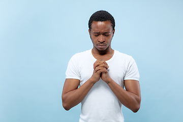 Image showing Half-length close up portrait of young man on blue background.