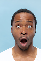 Image showing Close up portrait of young man on blue background.