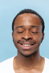Image showing Close up portrait of young man on blue background.