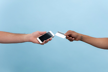 Image showing Close up shot of human holding hands isolated on blue studio background.