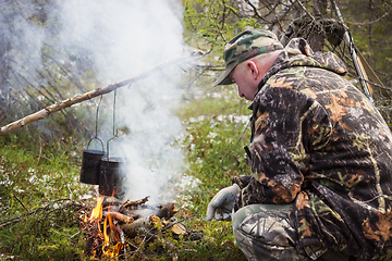 Image showing Huntsman has been cooking over a campfire