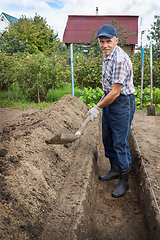 Image showing Man is digging the earth to build deep bed of