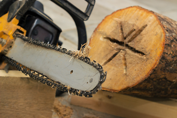 Image showing Making birdhouse from logs with chainsaw