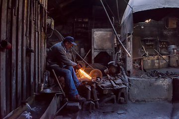 Image showing the blacksmith polishing metal products