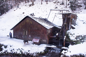 Image showing confident senior blacksmith in front of watermill