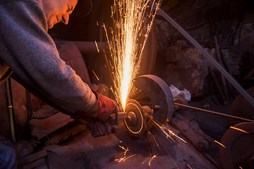 Image showing the blacksmith polishing metal products