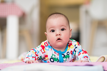 Image showing newborn baby boy playing on the floor