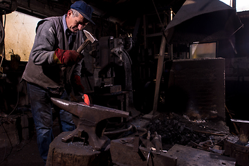 Image showing blacksmith manually forging the molten metal
