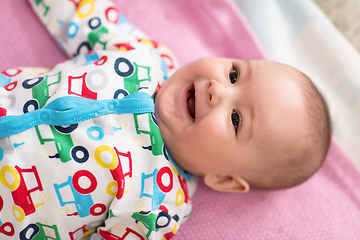 Image showing top view of newborn baby boy lying on colorful blankets