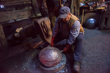 Image showing blacksmith workers using mechanical hammer at workshop