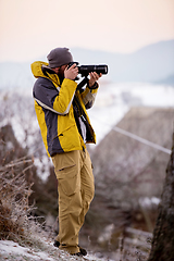 Image showing male photographer taking photographs of winter forest