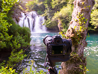 Image showing profesional DSLR camera on a tripod at beautiful waterfall