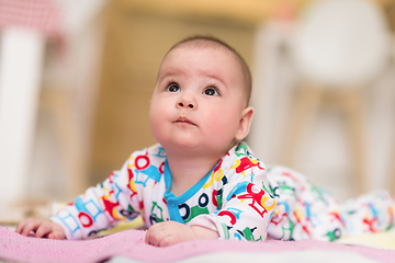 Image showing newborn baby boy playing on the floor