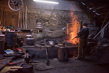 Image showing young traditional Blacksmith working with open fire