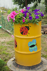 Image showing Flowers blooming in the old barrel