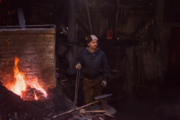 Image showing young traditional Blacksmith working with open fire
