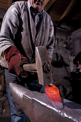 Image showing blacksmith manually forging the molten metal