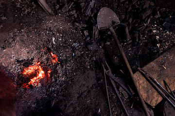 Image showing top view of traditional blacksmith furnace with burning fire