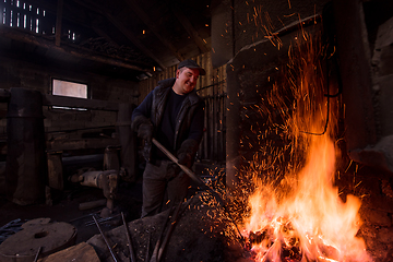 Image showing young traditional Blacksmith working with open fire