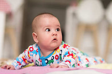 Image showing newborn baby boy playing on the floor