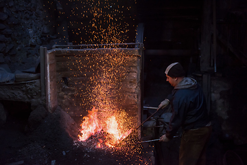 Image showing young traditional Blacksmith working with open fire