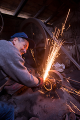 Image showing the blacksmith polishing metal products