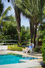 Image showing Elderly tourist resting by the pool