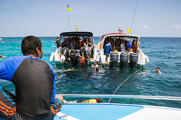 Image showing Tourists descend from boat into sea to swim