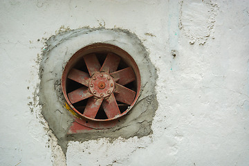 Image showing Old rusty fan inserted into wall