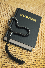 Image showing Rosary on Bible put on a straw table surface