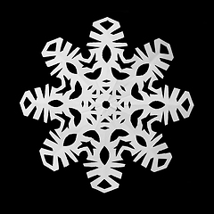 Image showing Snowflake cut out of paper on a black background