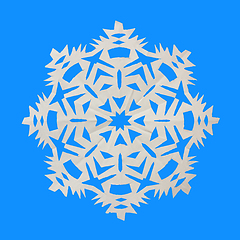 Image showing Snowflake cut from paper and lies on blue background