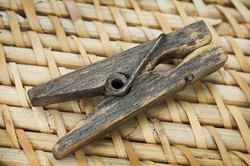 Image showing Decrepit  wooden clothespin on straw mat