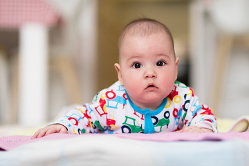 Image showing newborn baby boy playing on the floor