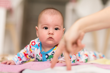 Image showing newborn baby boy playing on the floor