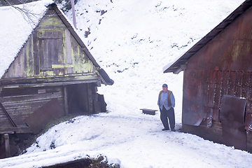 Image showing traditional senior blacksmith in front of watermill